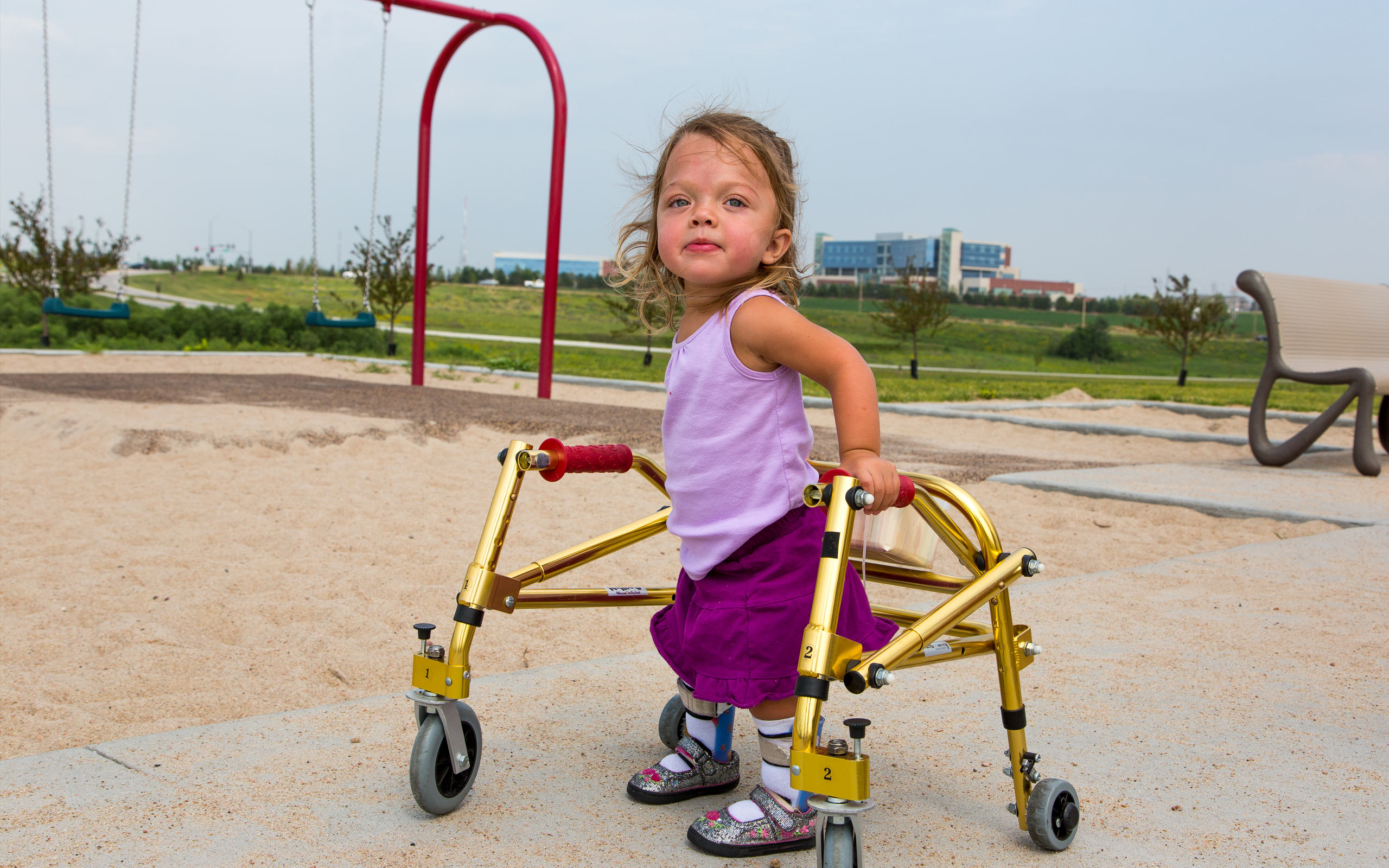 Evie, diagnosed with HPP at 2 weeks old, playing on a playground